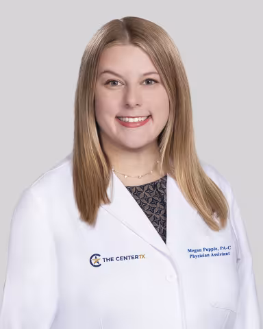 Smiling woman in a white medical coat with shoulder-length blonde hair.