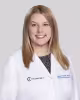 Smiling woman in a white medical coat with shoulder-length blonde hair.