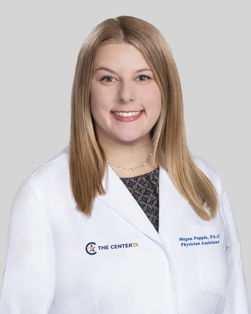 Smiling woman in a white medical coat with shoulder-length blonde hair.